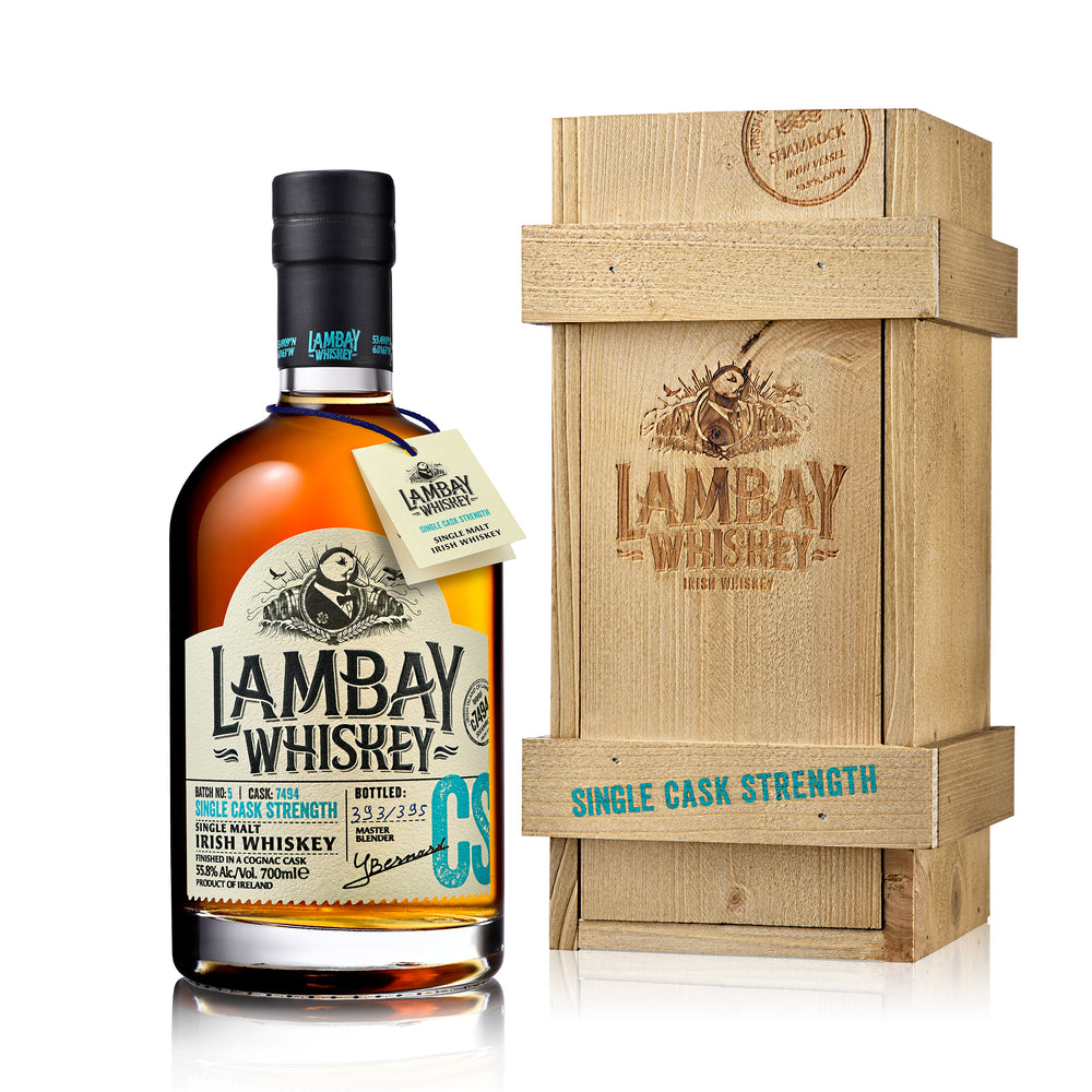 A bottle of Lambay Single Cask Strength Whisky next to its wooden crate box packaging.